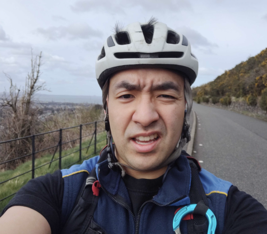 Close up of cyclist wearing helmet with a country road in the background