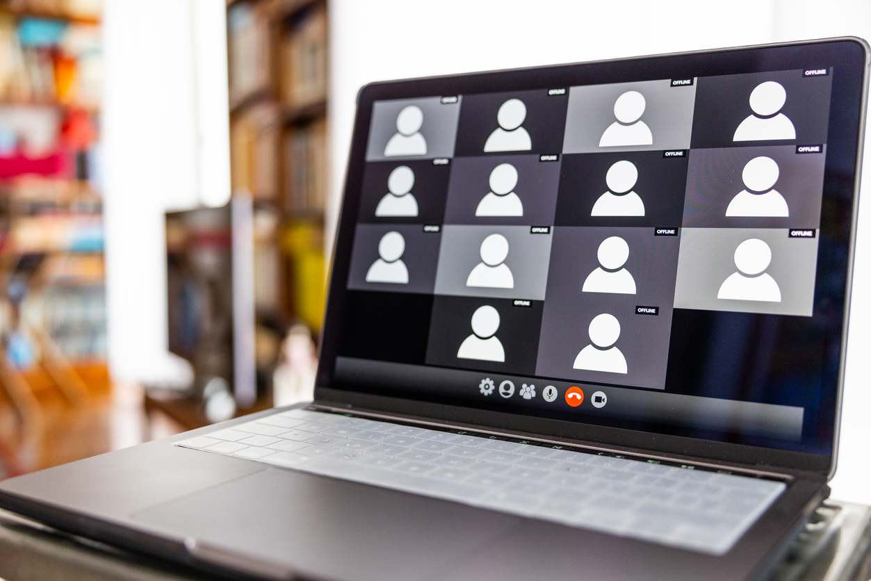 Laptop showing multiple people taking part in a remote online meeting