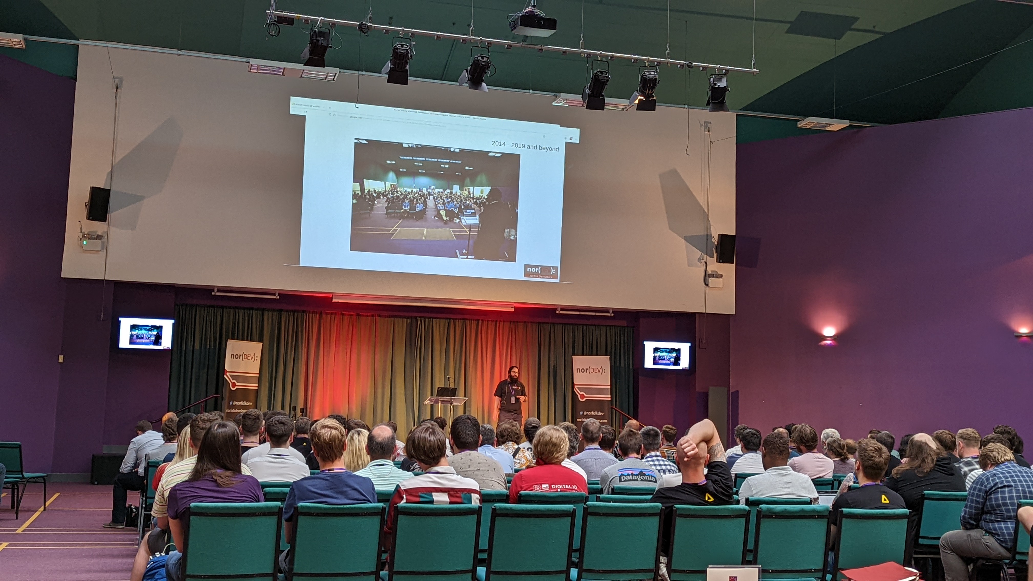 Speaker giving a visual presentation to an auditorium of people