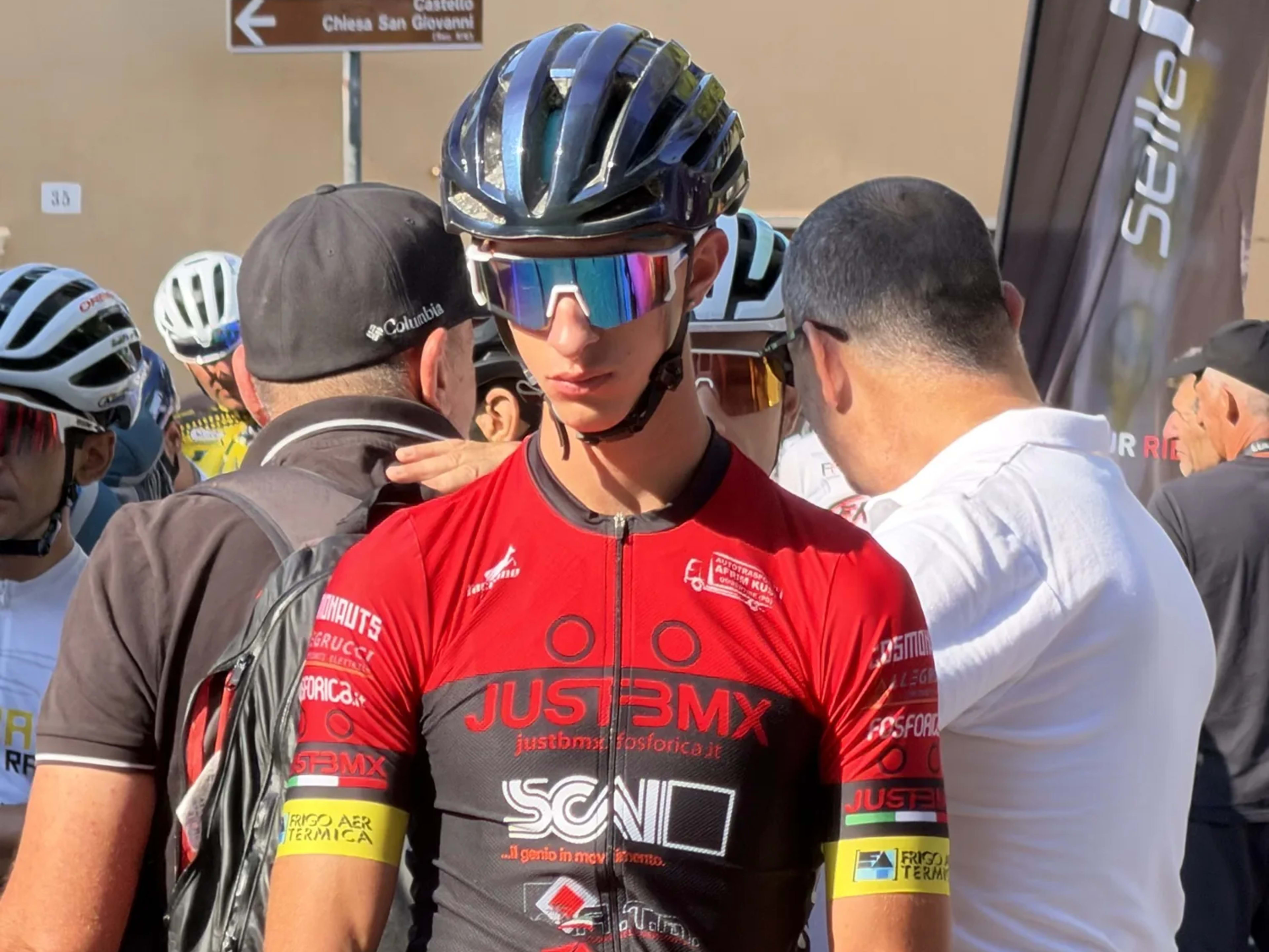 Giovane biker concentrato in griglia mentre riceve indicazioni prima della gara