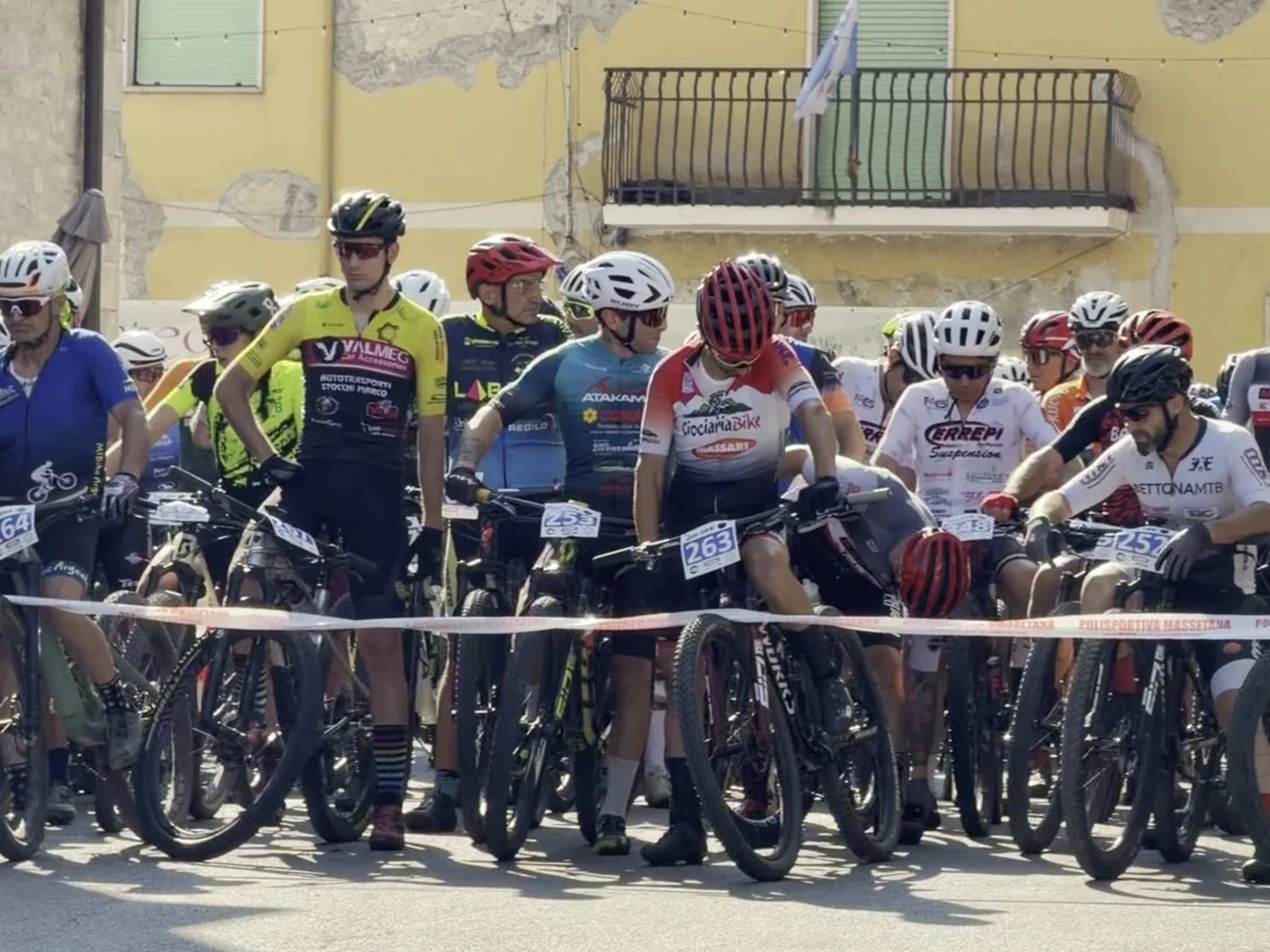 Folto schieramento di atleti pronti al via in una via del borgo