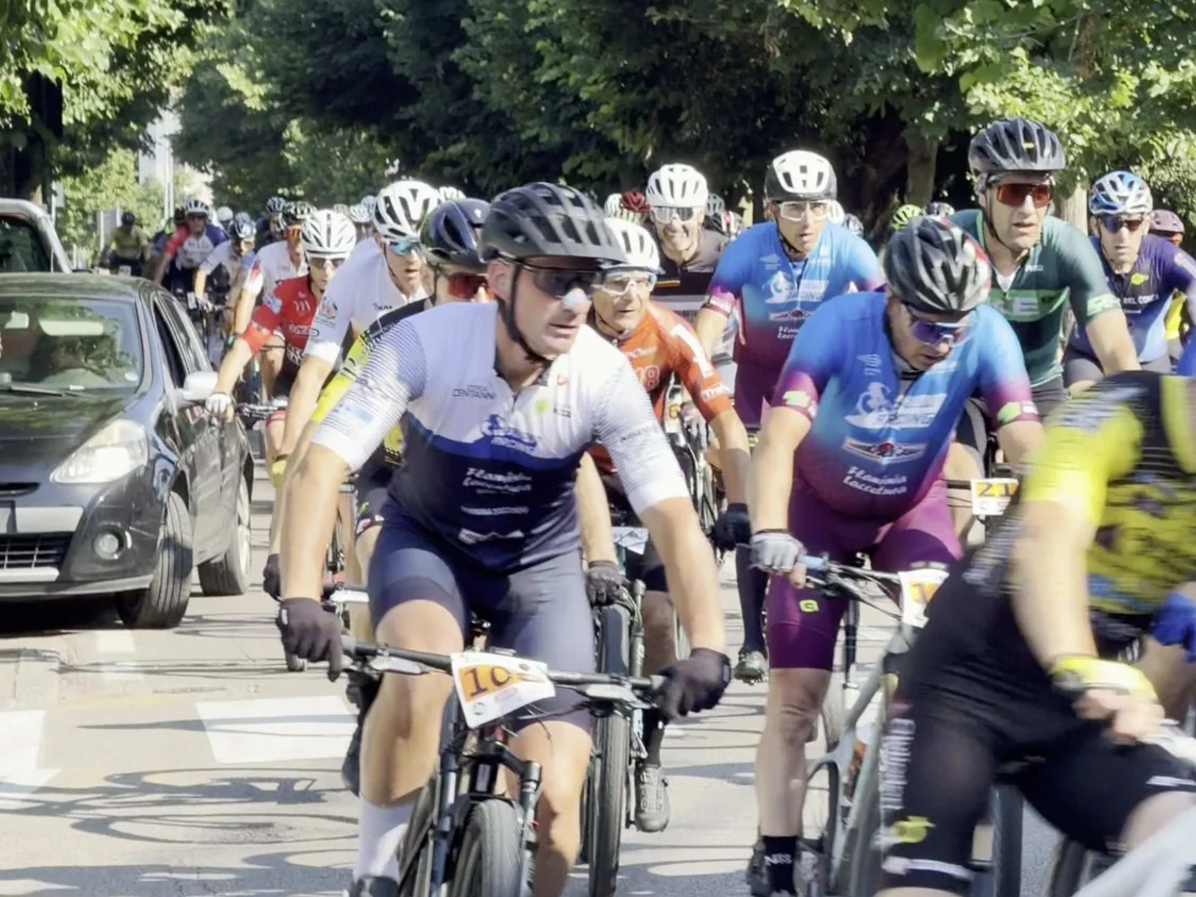 Gruppo di mountain biker pedala lungo la strada all'avvio della marathon