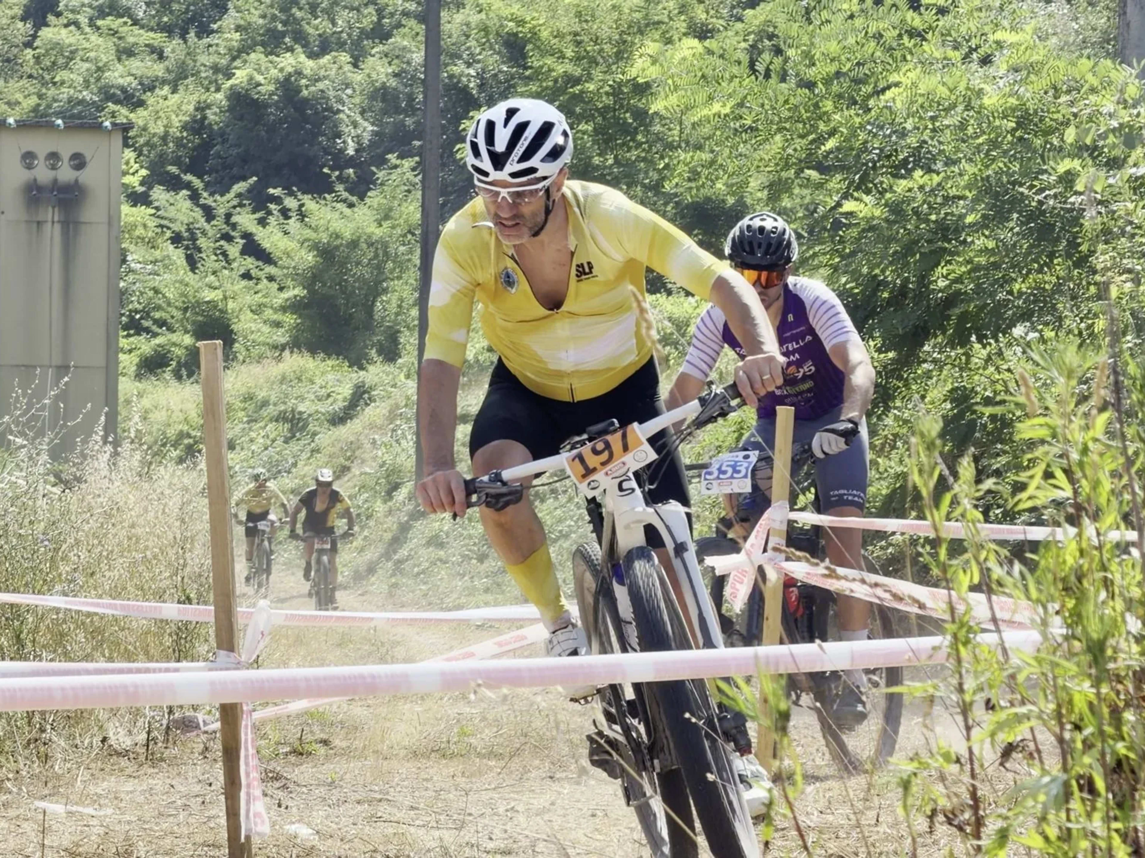 Biker in maglia gialla affronta lo sterrato seguito dagli inseguitori
