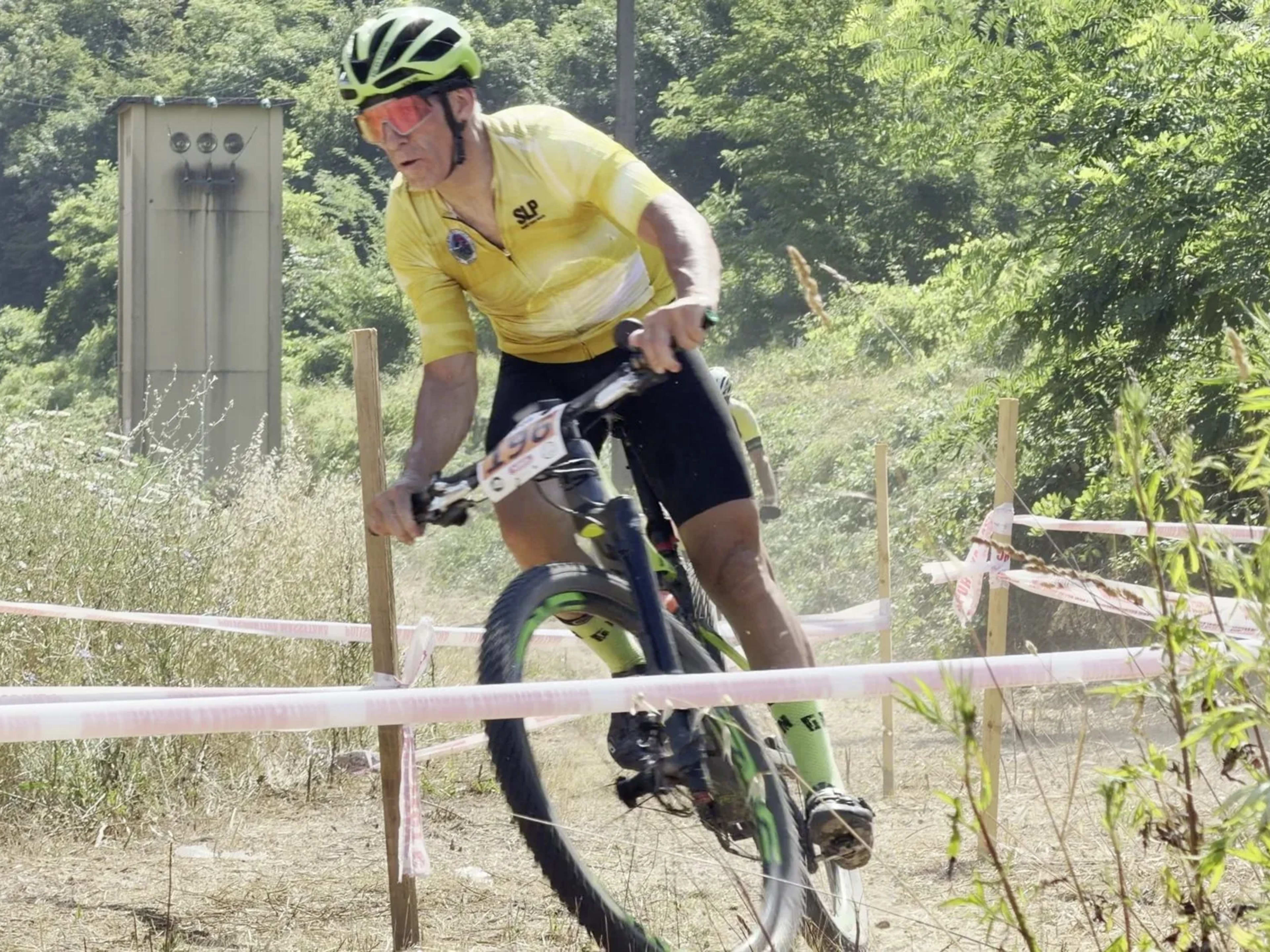 Mountain biker affronta una curva sullo sterrato delimitato dal nastro