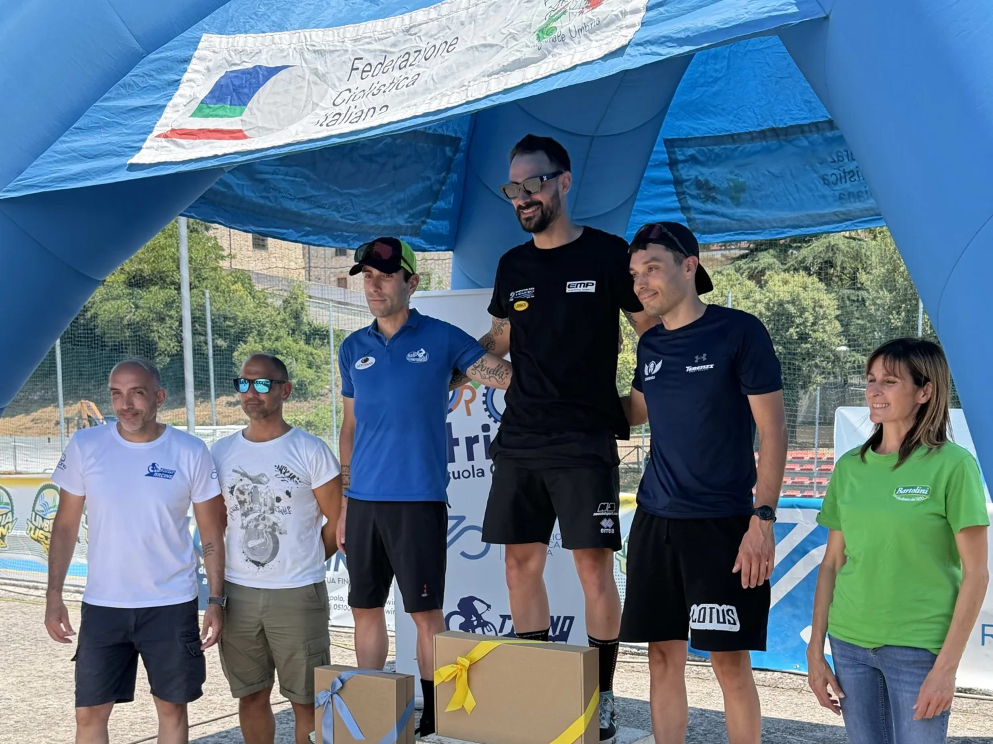 Cerimonia di premiazione sotto l'arco gonfiabile della Federazione Ciclistica