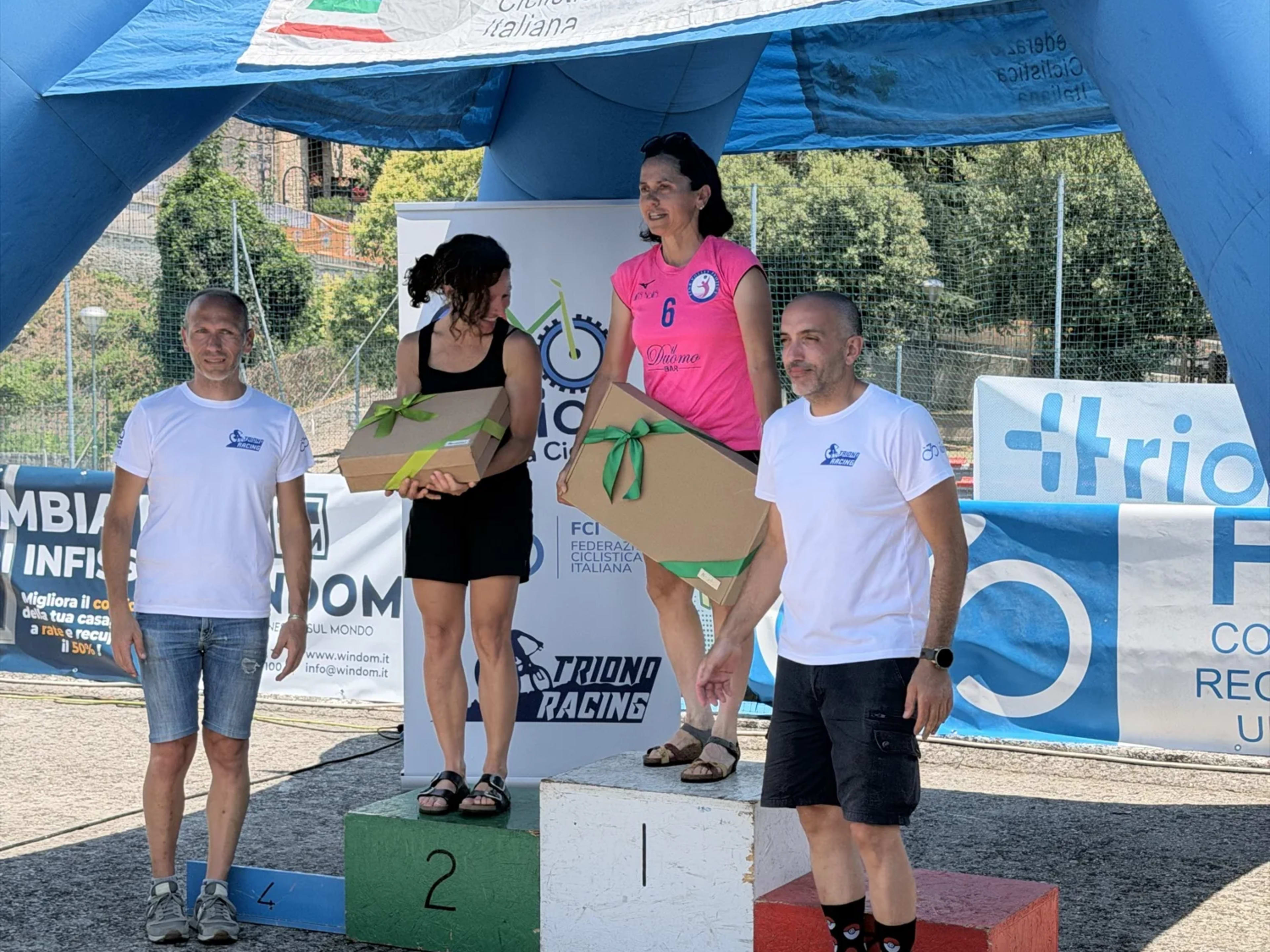 Premiazione mista sul podio con i pacchi-premio e mazzi di fiori