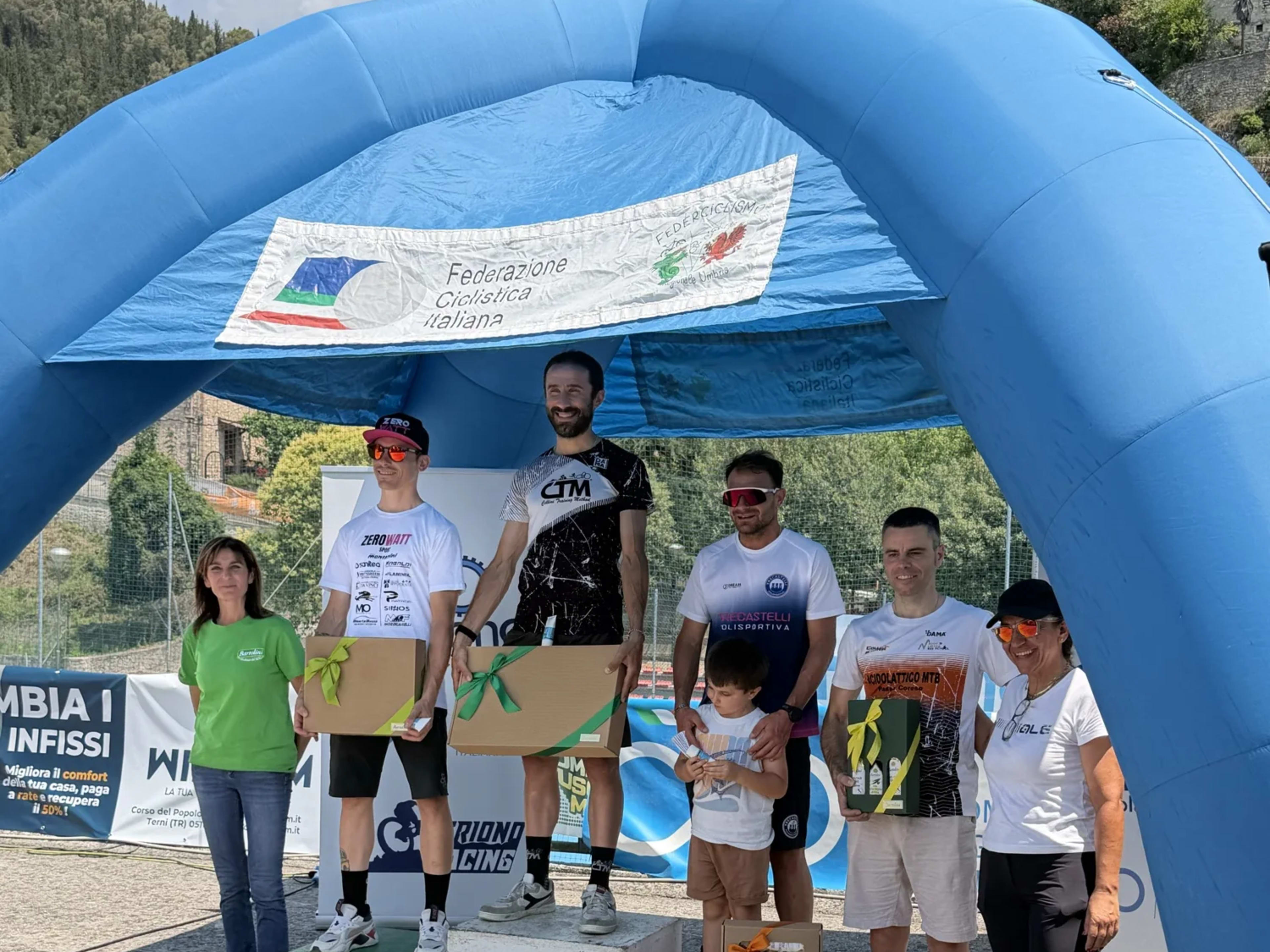 Podio con i primi cinque classificati e un bambino accanto ai premiati