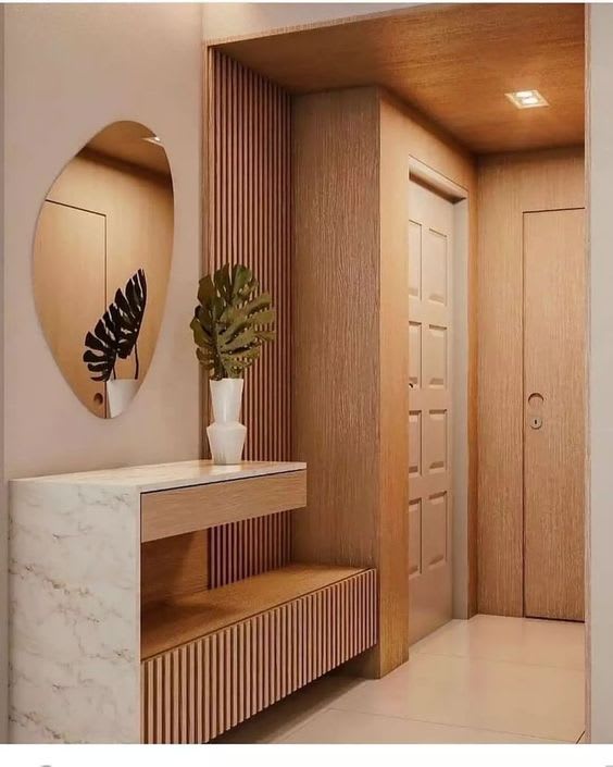 Home entryway by Vyom Interiors Delhi with wall panels, console table, and round mirror