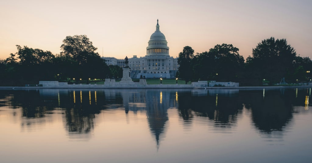 The U.S. Capitol is reflected in the water.