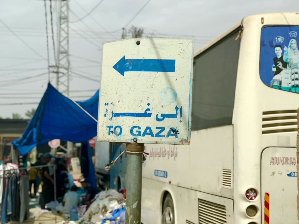 A White Bus Parked Next to a Blue and White Sign Photo