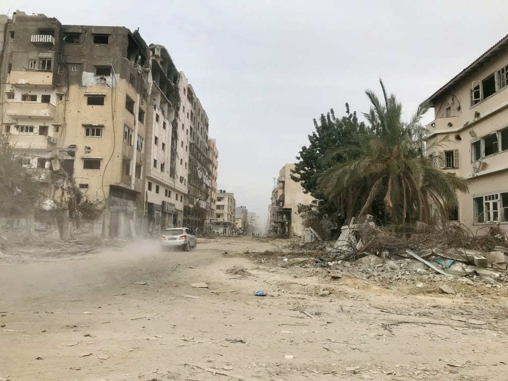 A Car Driving Down a Dirt Road in Gaza