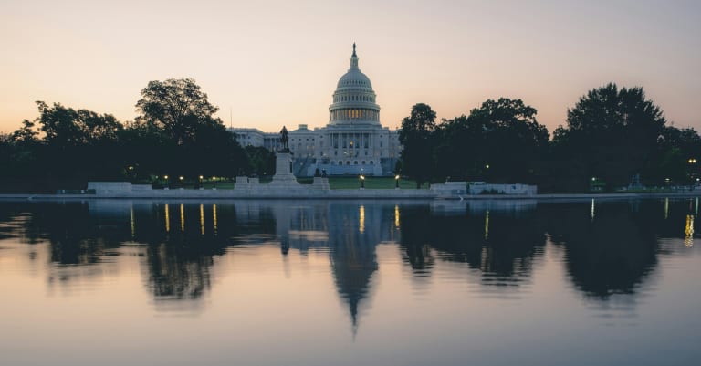 The U.S. Capitol is reflected in the water.