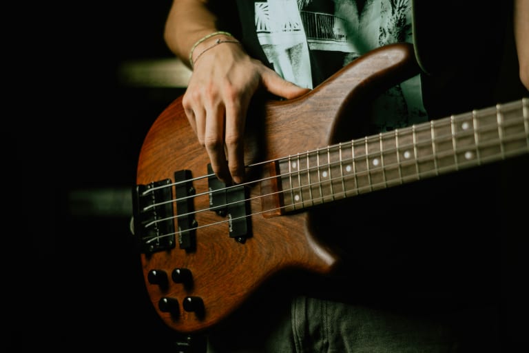 A Person Holding a Brown and Black Electric Guitar