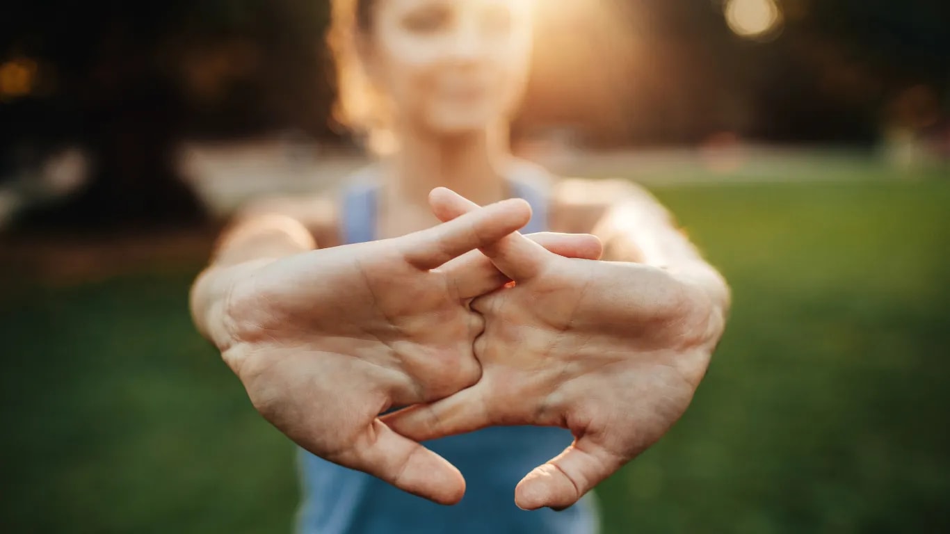 Interlace fingers and stretch palms outward