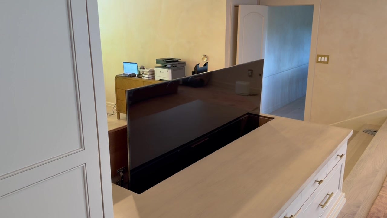 Pop-up television lift rising from custom cabinetry in a living room — Ermine Smart Home, Los Angeles