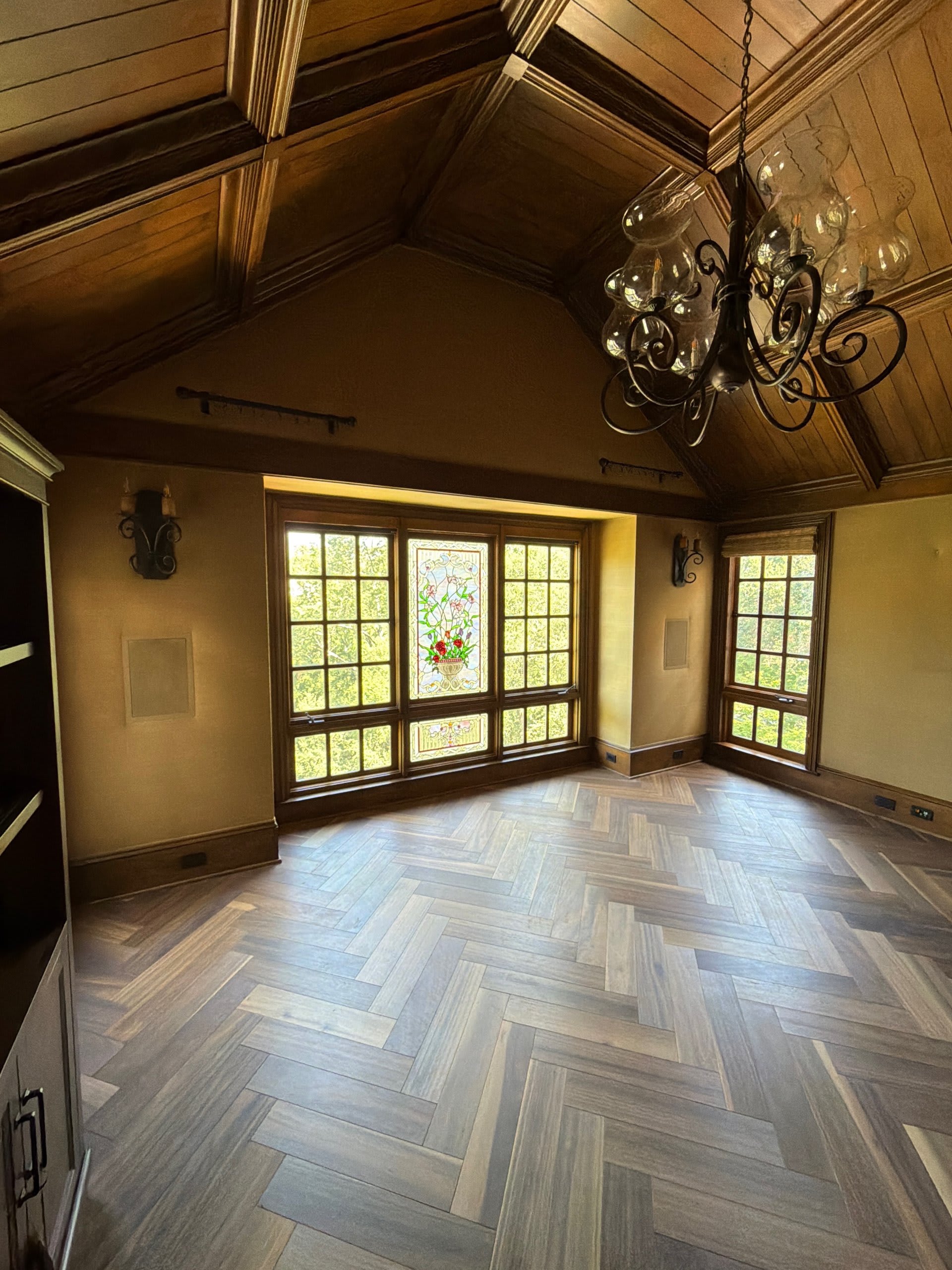 Discreet audio and control integration in a wood-paneled living room with stained glass — Ermine Smart Home, Los Angeles