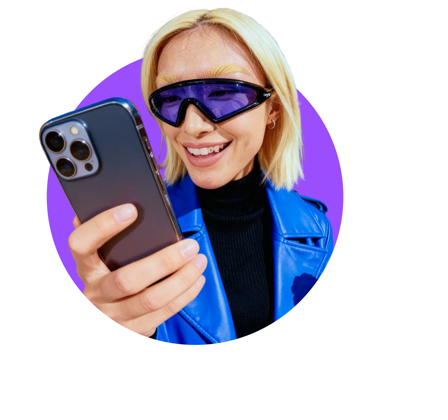 Person in a blue jacket and tinted visor-style sunglasses smiling while looking at their phone against a light circular background.