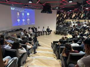 Three young men in suits posing under a stone archway outdoors