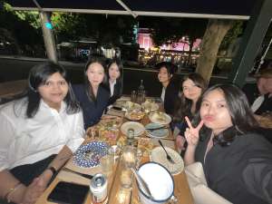 Friends gathered around a table at a casual restaurant taking a selfie