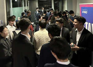 Gathering of friends at dinner table, smiling at camera
