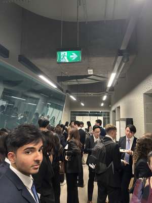 Busy hallway outside of event, one person glances at the camera