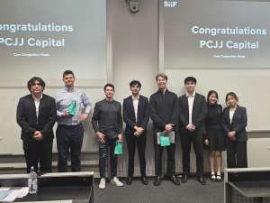 Three young women posing together indoors, smiling and making peace signs