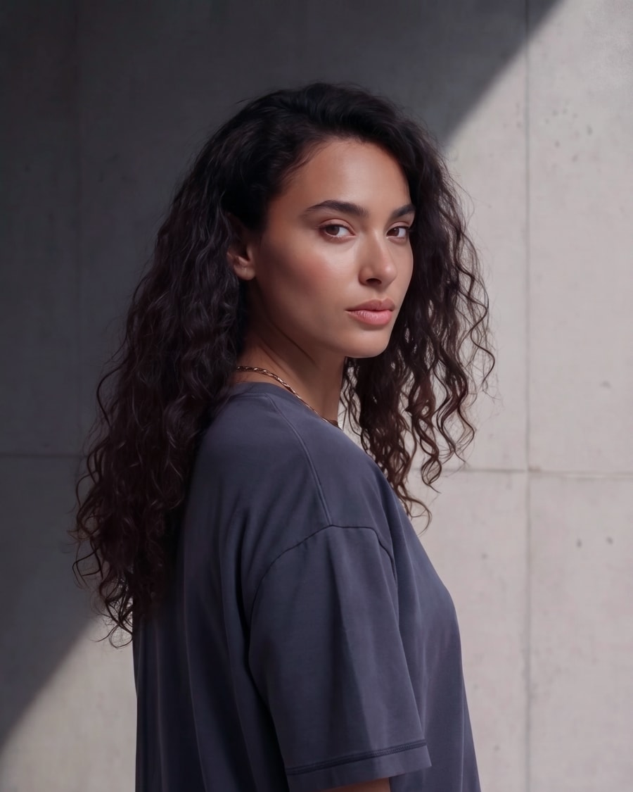 365.APParel Basic T-shirt Graphite — woman, cropped upper body, looking over shoulder, concrete wall, outdoor