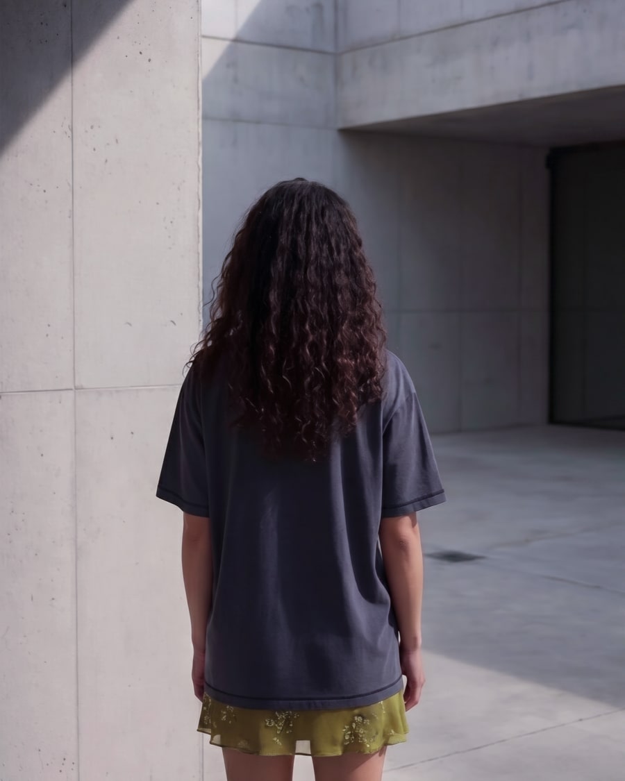 365.APParel Basic T-shirt Graphite — woman, full body back view, concrete architecture, outdoor
