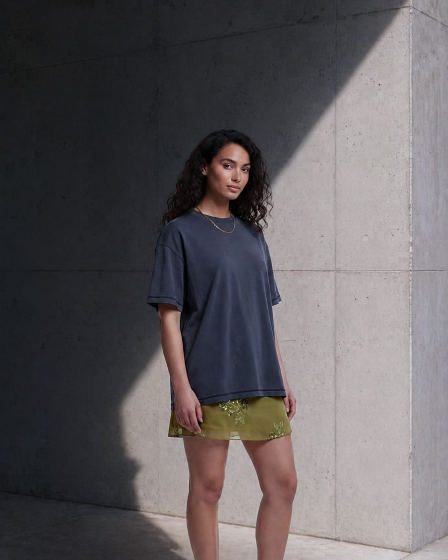 365.APParel Basic T-shirt Graphite — woman, full body, three-quarter side view, concrete wall, outdoor