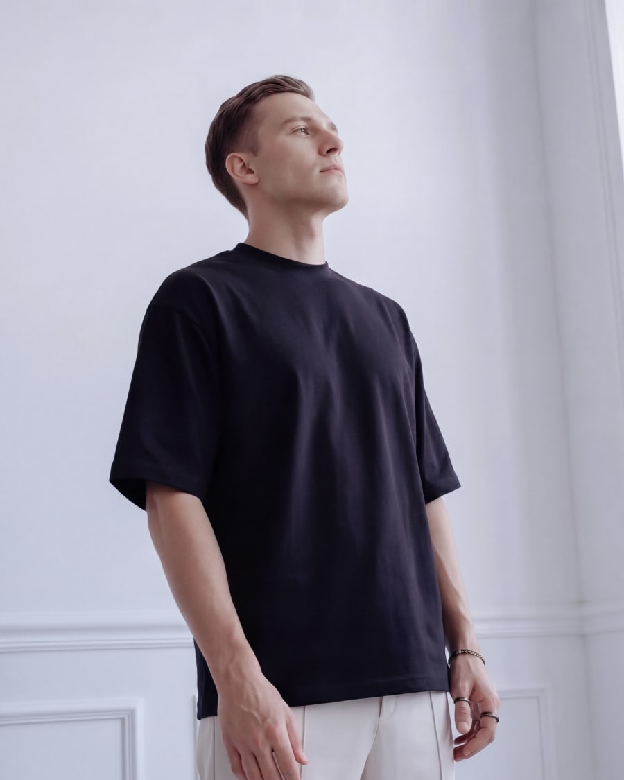 365.APParel Oversize T-shirt Black — man, full body front, looking up, indoor editorial