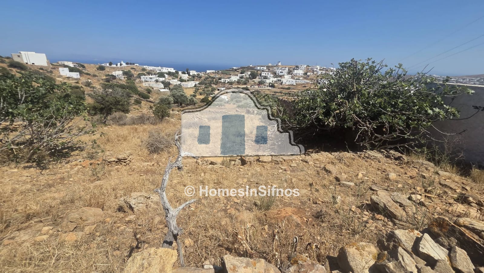 Plot for sale in Artemonas Sifnos with old stone buildings.
