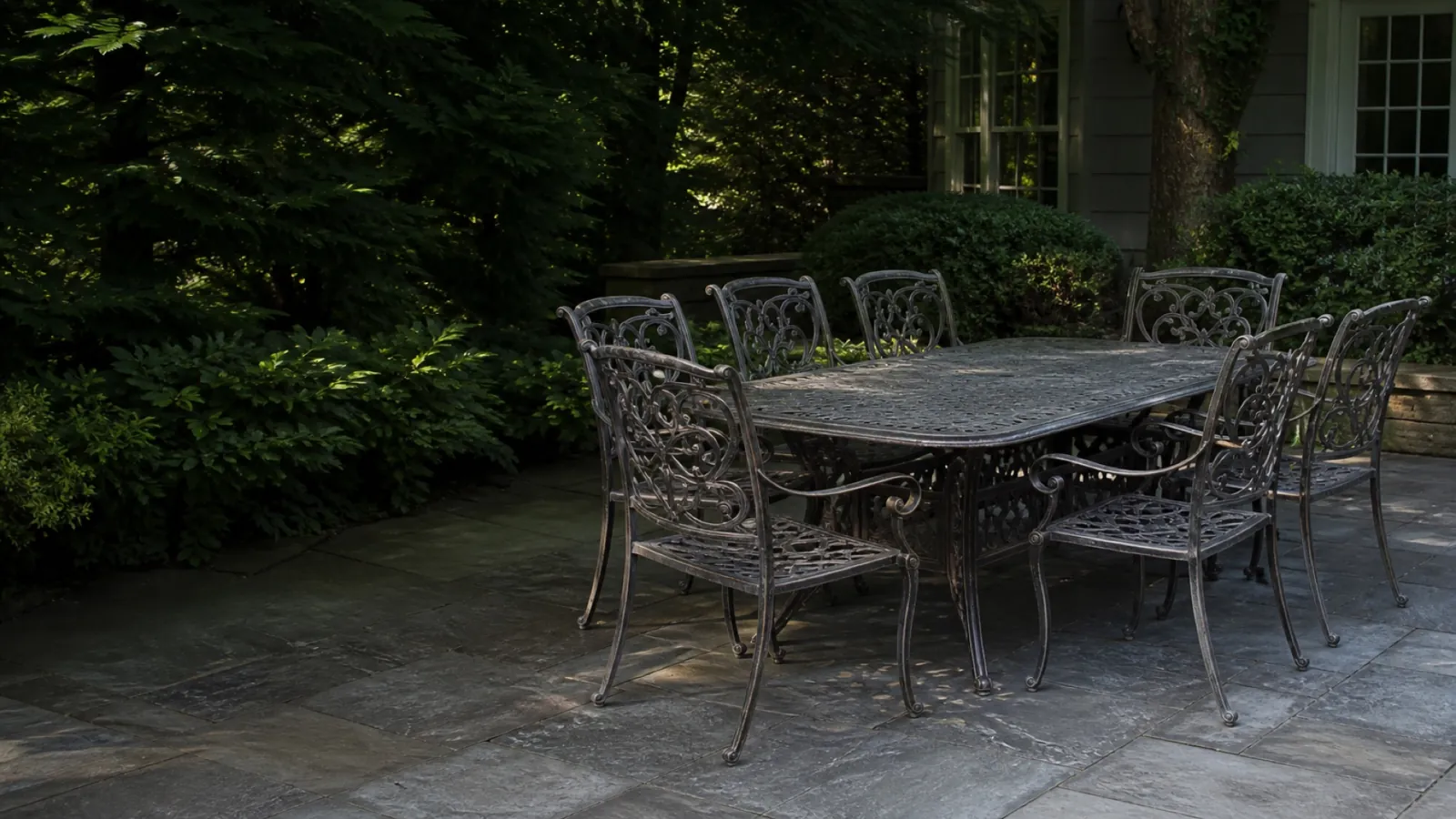 An ornate weathered cast aluminum patio dining set