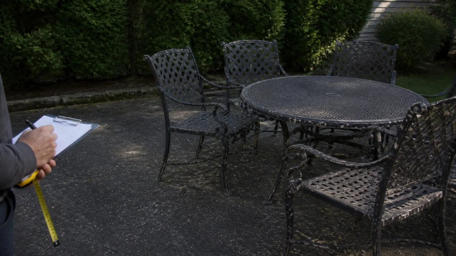 A weathered metal patio dining set being assessed