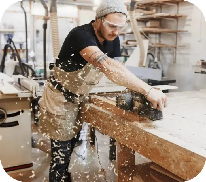 Carpenter working on a wooden board in a workshop