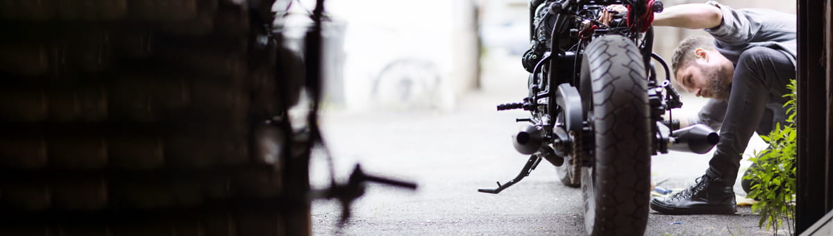 Man is bezig met een onderhoudsbeurt voor zijn motor