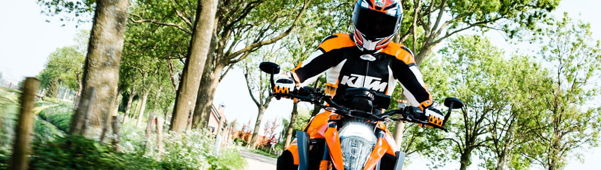 Motorrijder rijdend door het groene Brabantse landschap