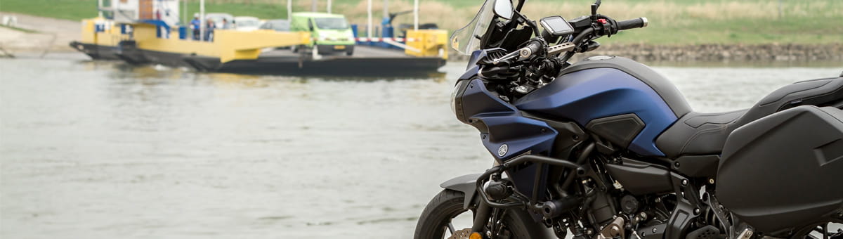 Geparkeerde motor wachtend om met een veerpont het water over te steken