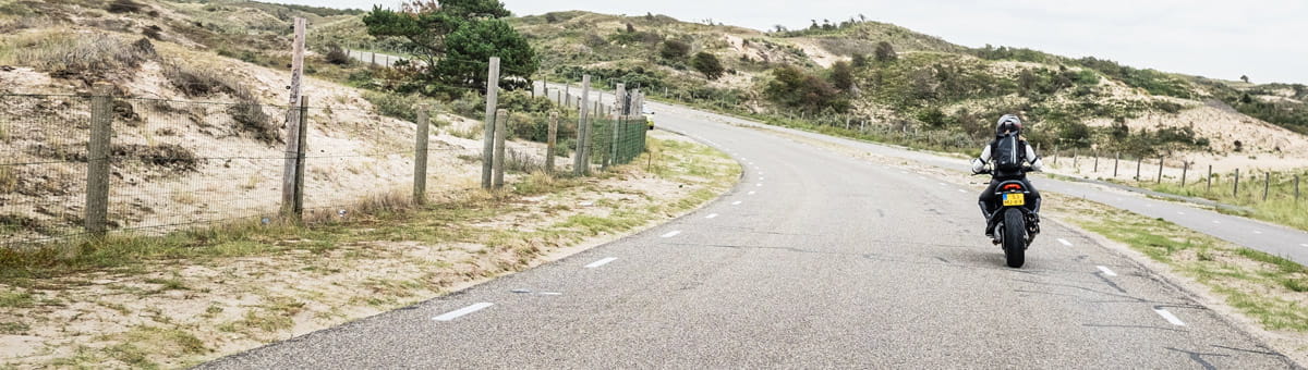 Motorrijder rijdt door de duinen