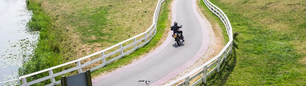 Motor rijdt over een watertje in Groningen
