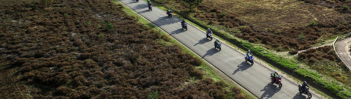 Motoren rijden over een weg op de hei