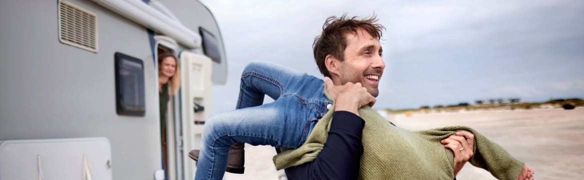 man en kind spelen bij camper