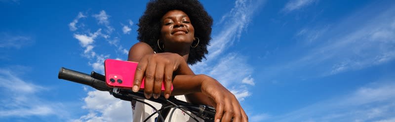 Vrouw op een fiets met telefoon in haar hand