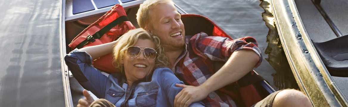 man en vrouw liggen samen in bootje in de zon