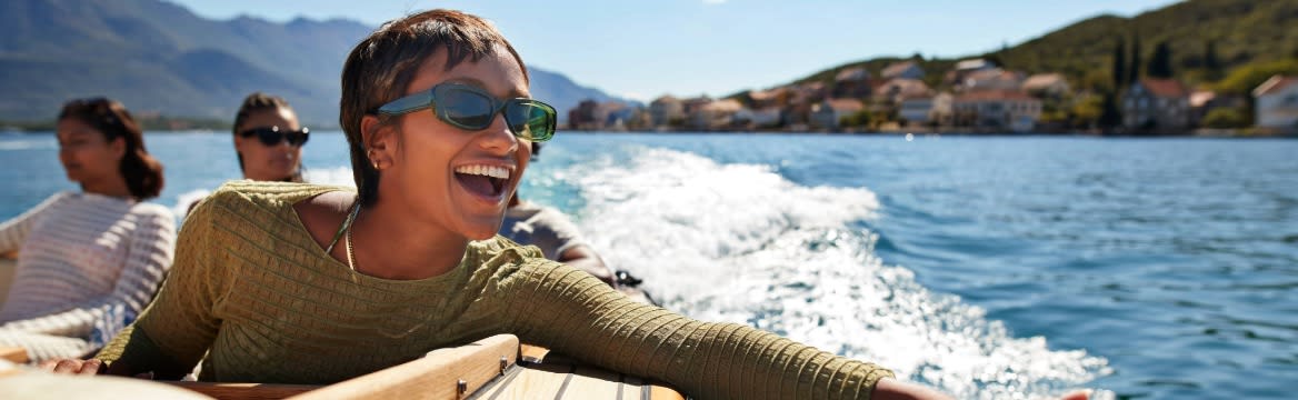 vrouw zit lachend op boot