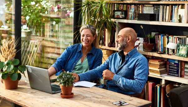 Foto OpGroen man en vrouw tevreden kijkend naar laptopscherm