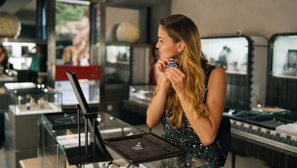 Vrouw past oorbellen van sieradencollectie