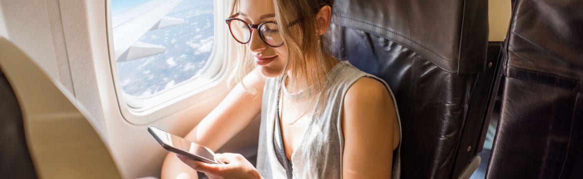 vrouw in vliegtuig op telefoon