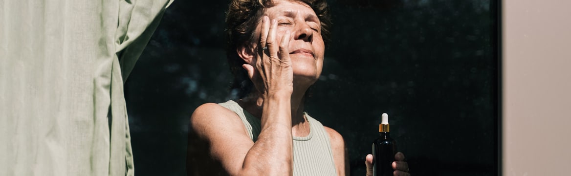 vrouw staat achter raam in de zon