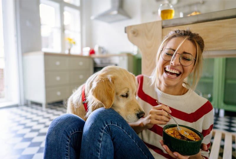 jonge vrouw aan het eten met hond