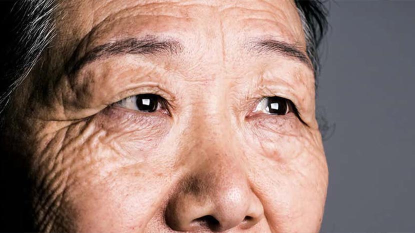 elderly asian woman man stares out the window